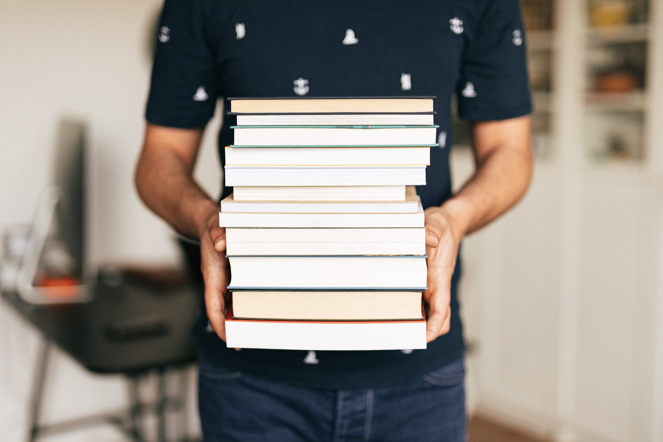 person holding a stack of books
